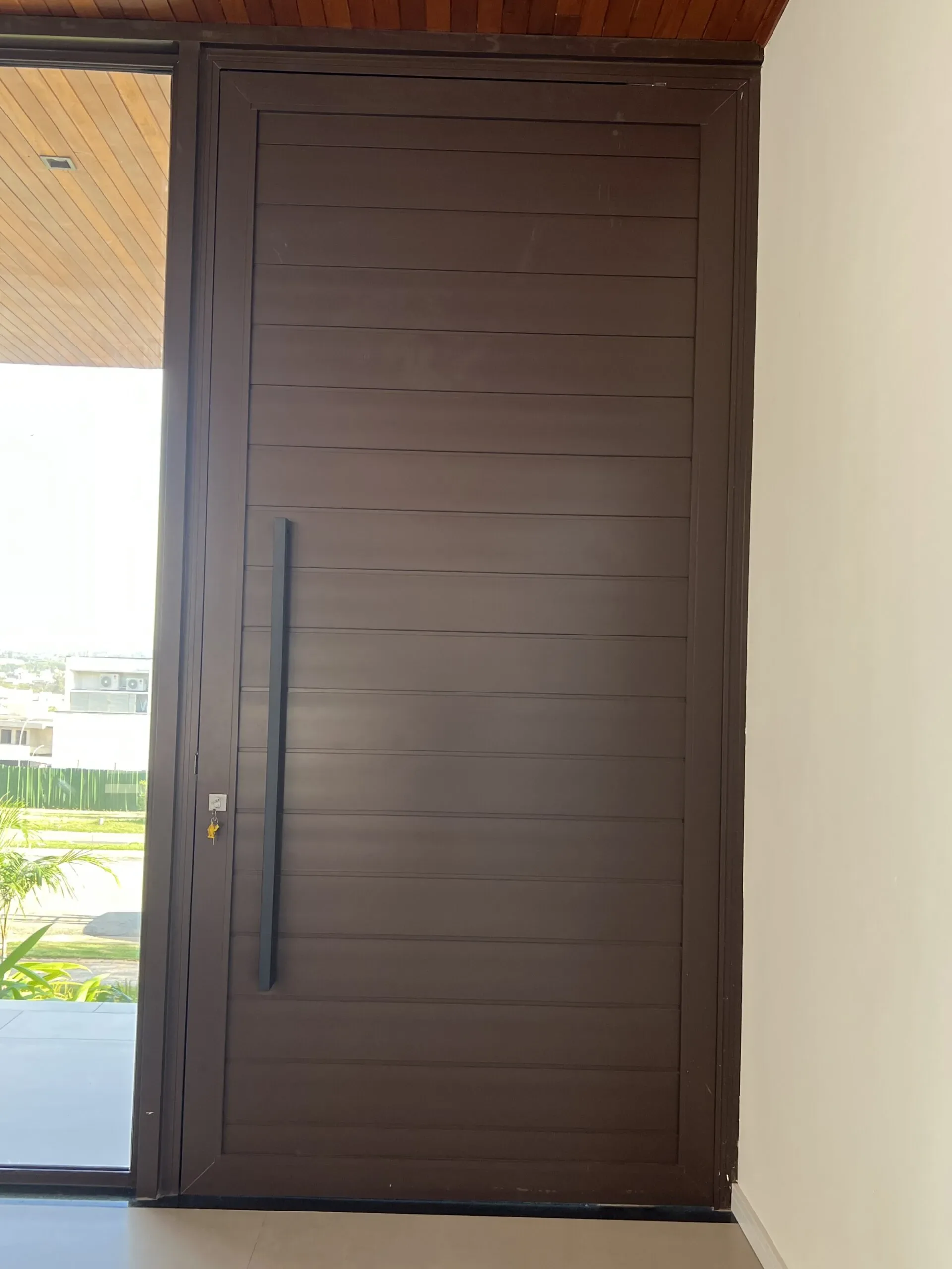 Vista do interior para o exterior através de painéis de vidro com esquadrias de alumínio