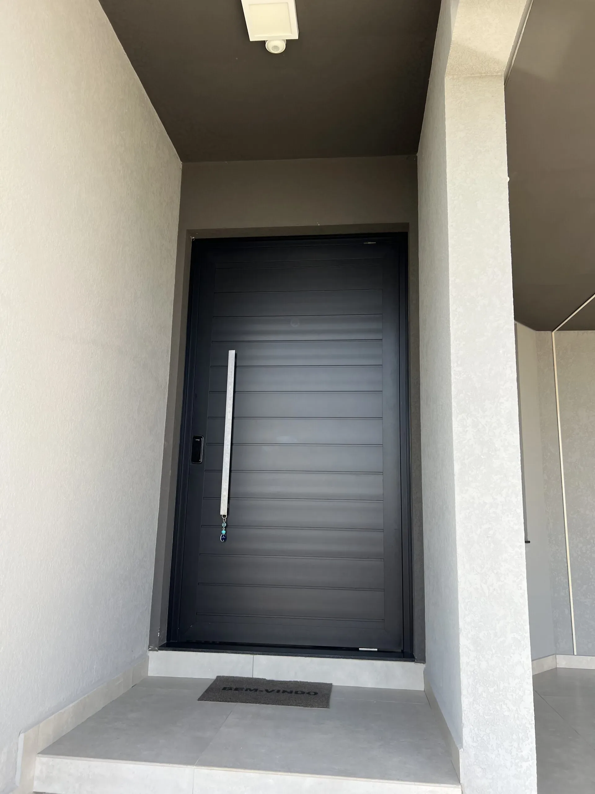Porta reta e minimalista de alumínio em tom escuro