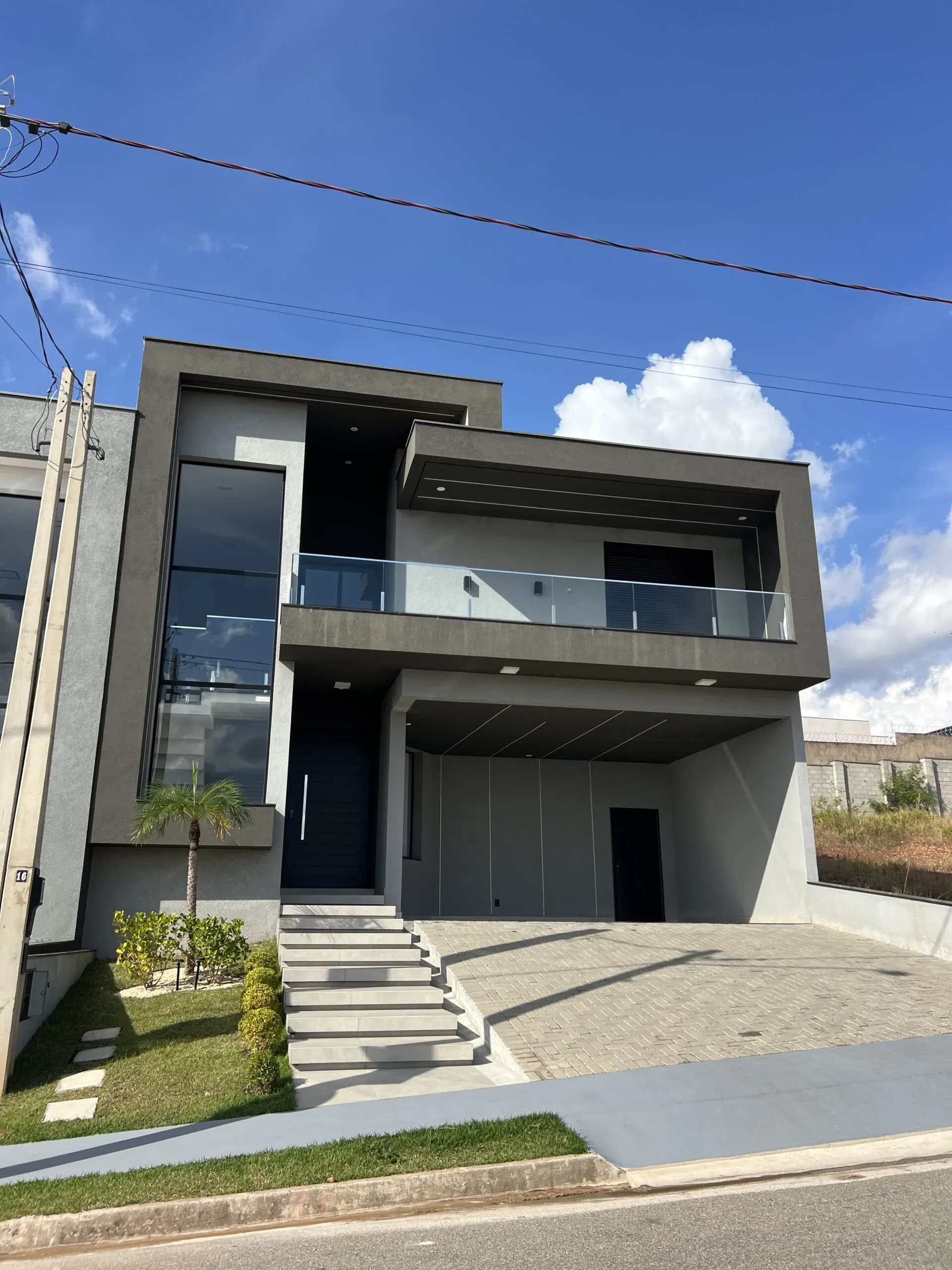 Casa moderna com guarda-corpo de vidro na varanda do pavimento superior