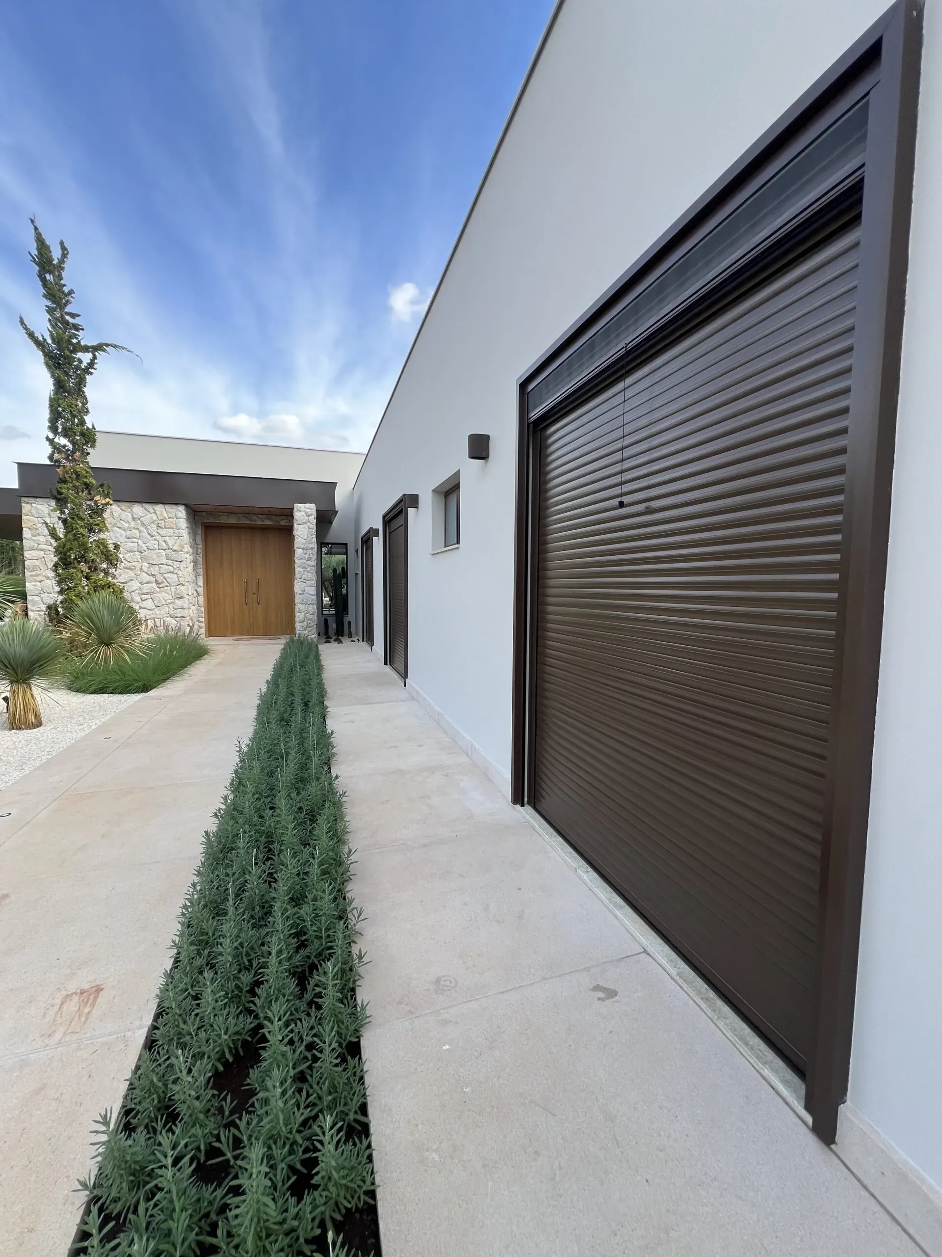 Portas de enrolar automáticas em alumínio marrom em fachada residencial